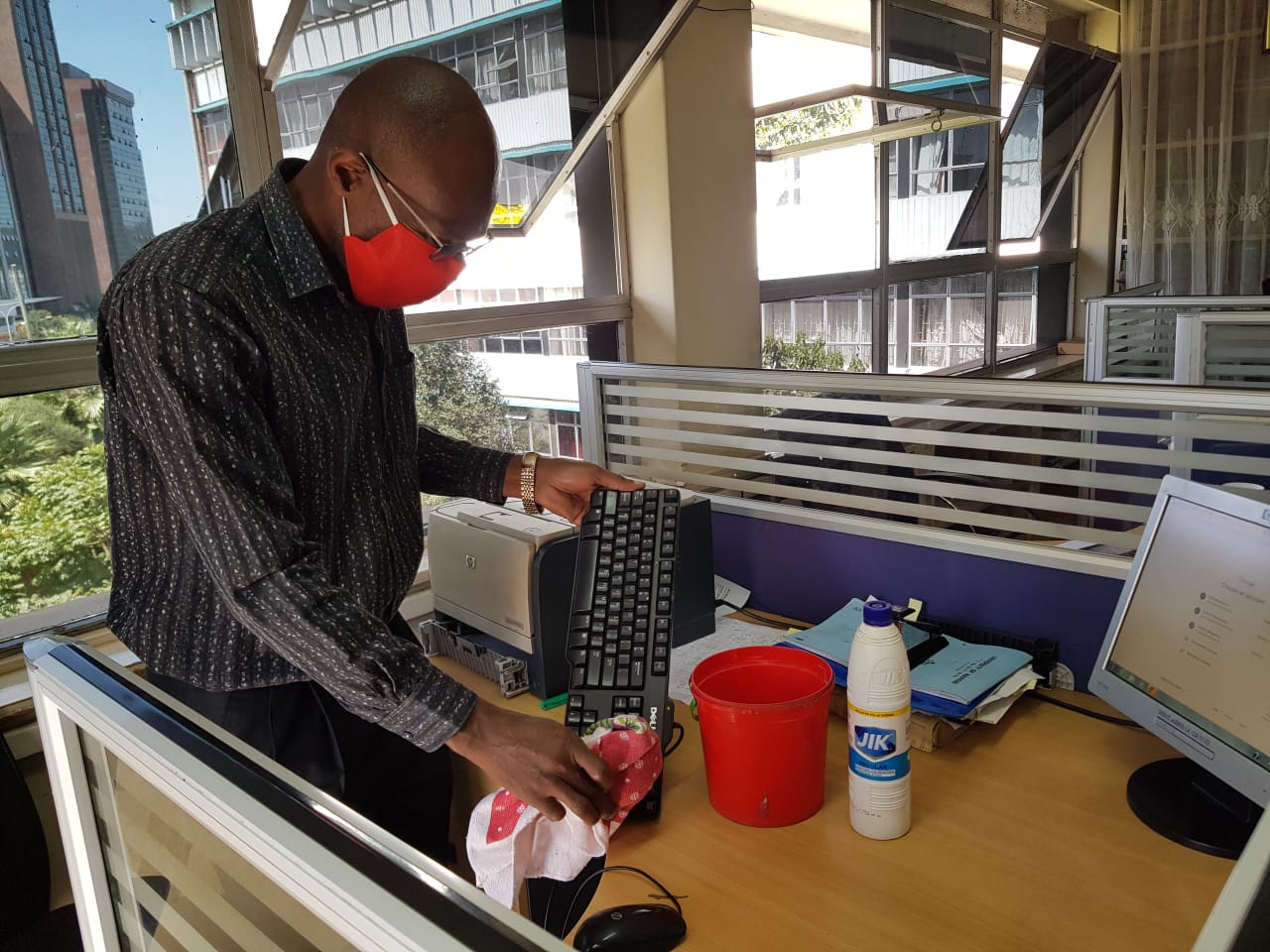James Langi a support staff from internal audit carrying out sanitisation of office equipment and surfaces as a precaution measure to prevent spread of Corona virus. Attachments area