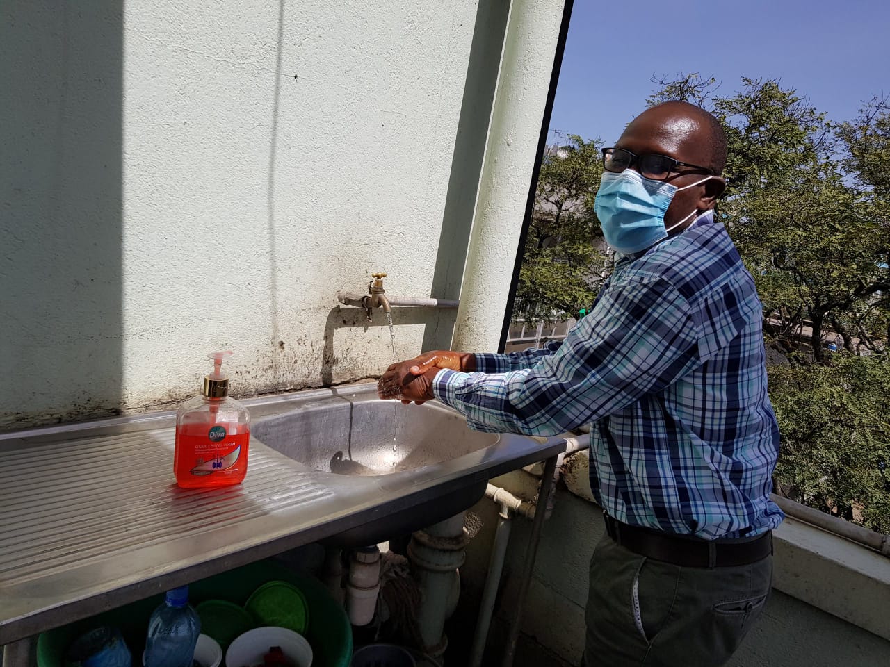 Evans Nyandumo, Senior Internal Auditor washing hands in one of the departments washing area to prevent spread of the virus. 