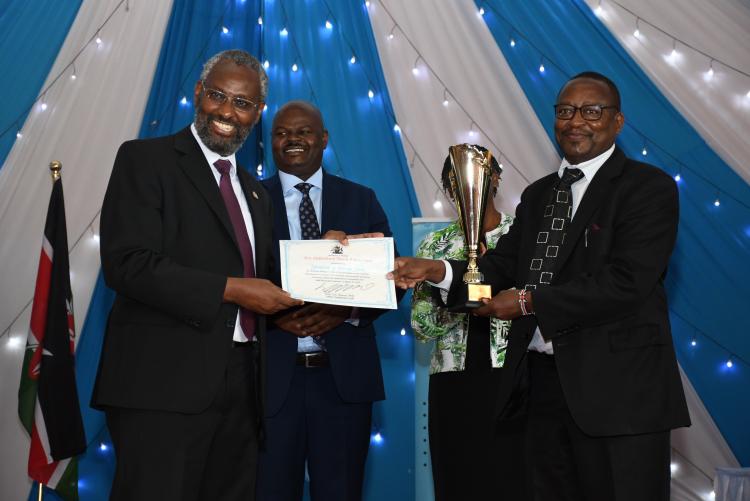 The VC hands the director Internal Audit the trophy and certificate